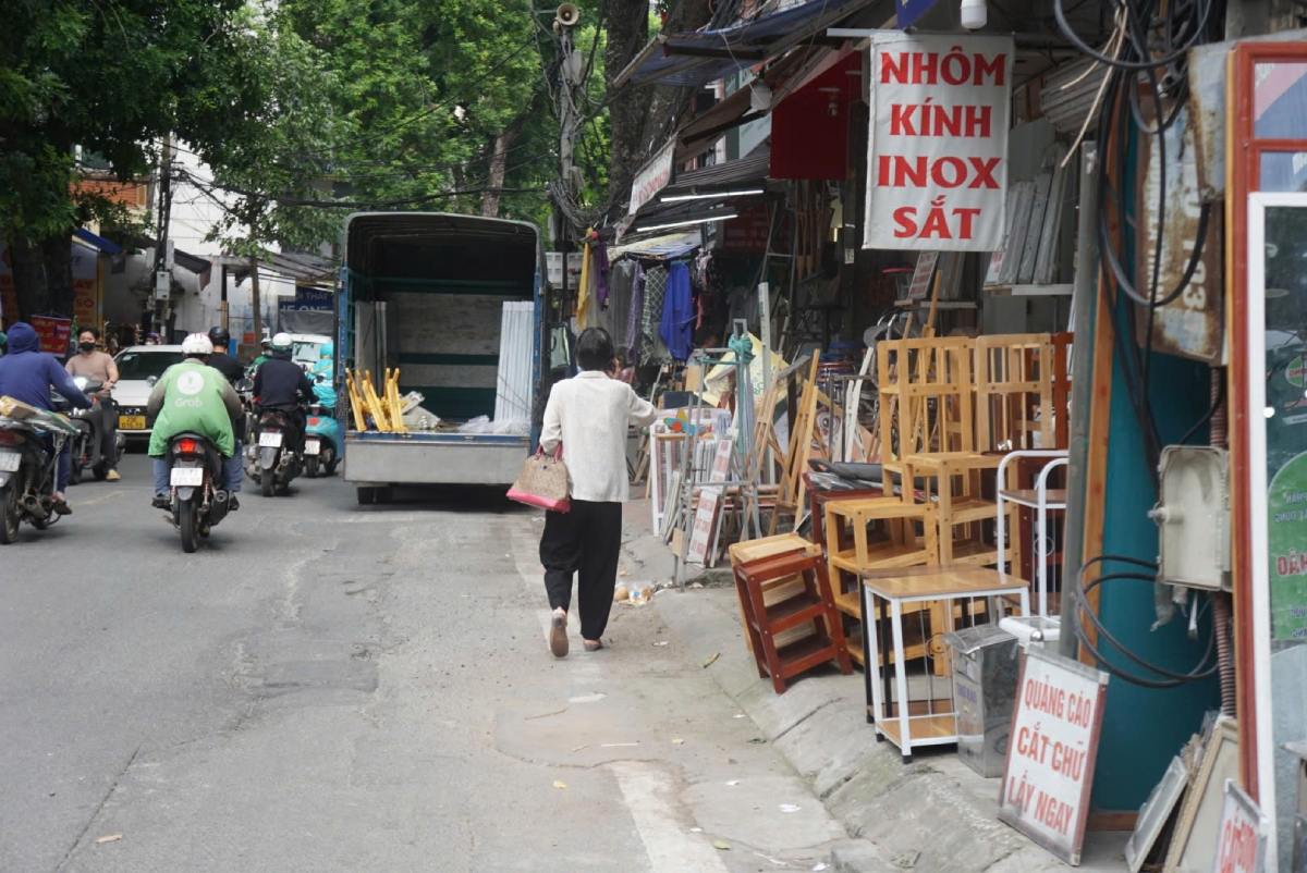 Vỉa hè tại đường Đê La Thành tràn ngập hàng hóa, người dân phải đi xuống lòng đường. Ảnh: Công Hòa