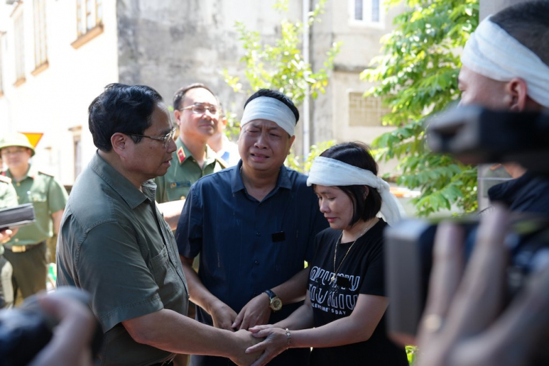 Thủ tướng Chính phủ Phạm Minh Chính đến thăm, động viên, chia sẻ với thân nhân gia đình bà Dương Thị Diệu và con trai là Hoàng Văn Tám bị thiệt mạng do sạt lở đất. Ảnh: Công an Nhân dân