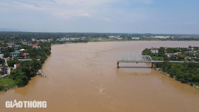 Trước đó, vào sáng 9/9, mưa lũ, khiến nước sông Hồng dâng cao, lưu tốc dòng chảy xiết làm thay đổi địa hình lòng sông, kéo đổ trụ T7 gây sập 2 nhịp dàn chính của cầu Phong Châu (nhịp 6 và 7). (Ảnh chụp ngày 9/9).